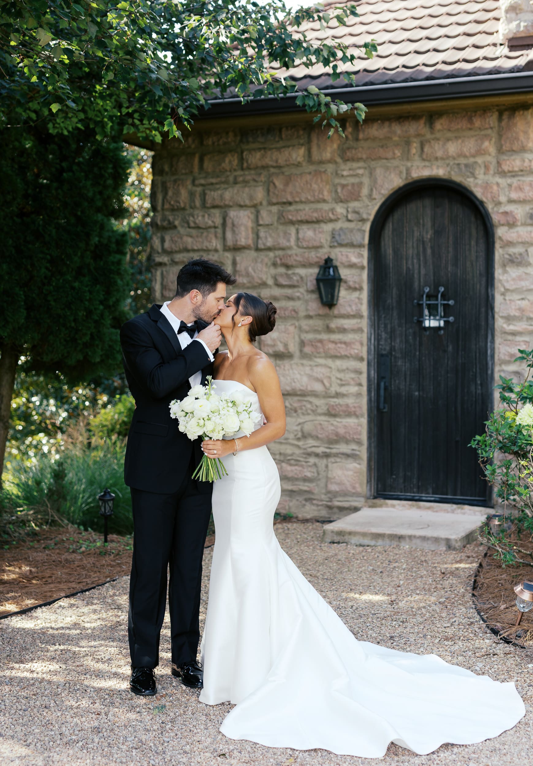 bride and group kissing in front of a stone wedding venue in Johnson City TN