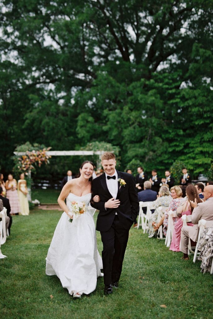 bride and groom walking up aisle smiling photographed on film during Tennessee wedding