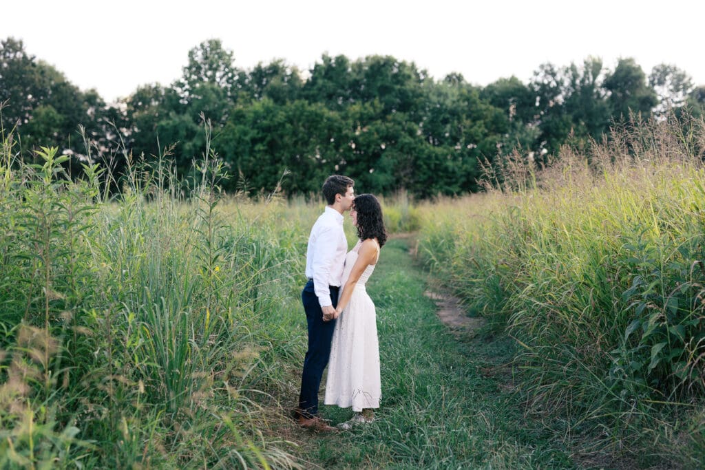 engaged couple embracing in a field in East Tennessee