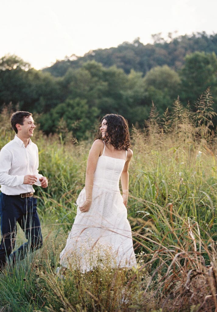natural engagement photo of couple walking together at sunset
