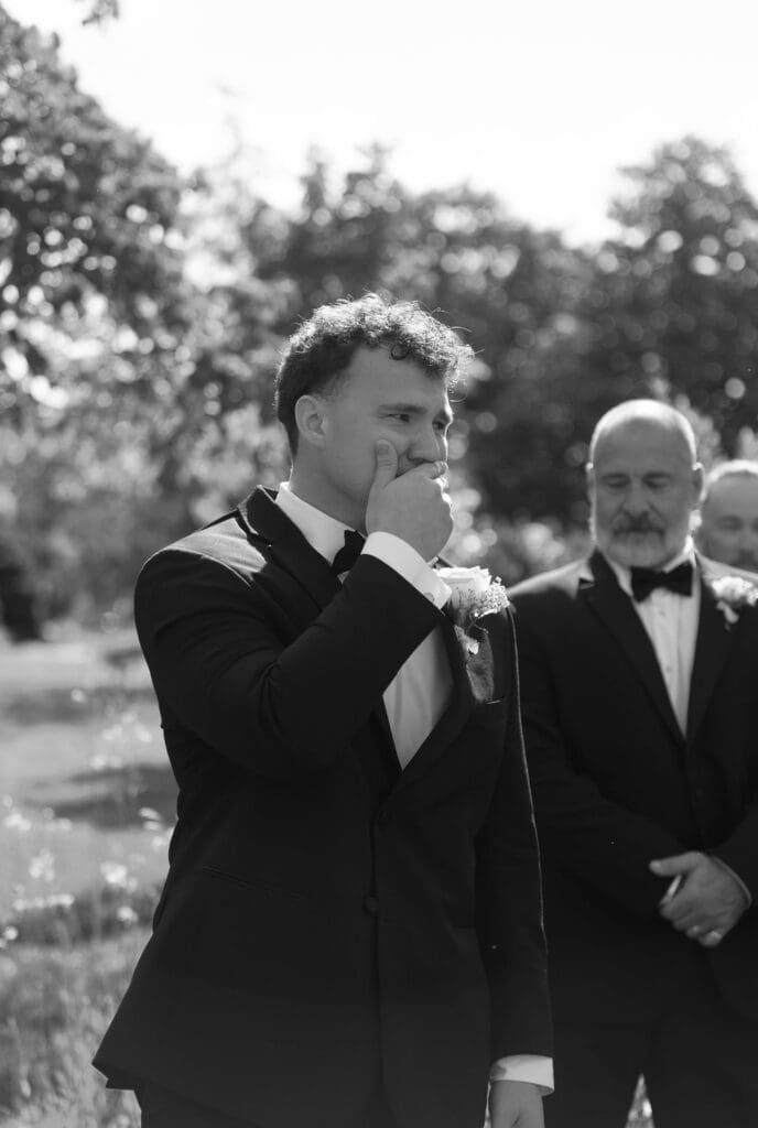 emotional groom seeing bride during outdoor wedding ceremony